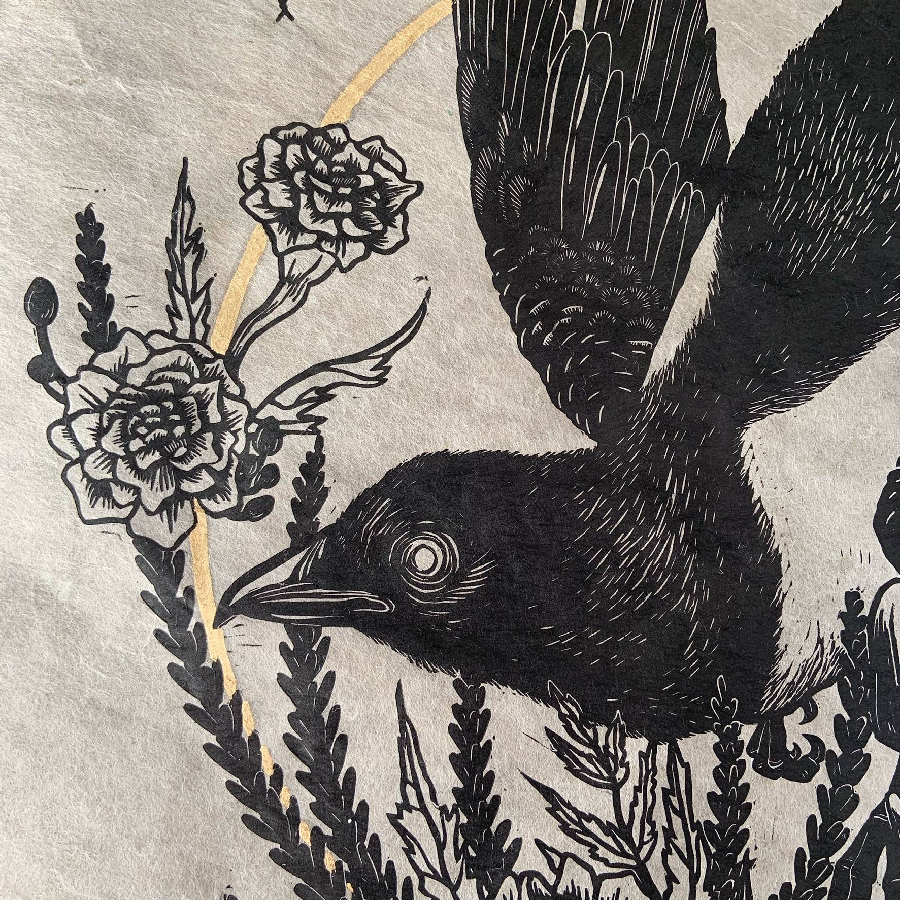 detail of linocut of blackbird with flowers around it and a gold leaf circle behind it
